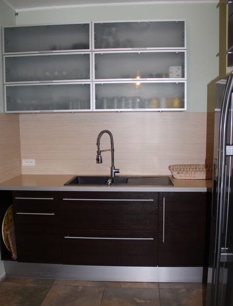 Kitchen: sink, glasses above, double fridge with ice dispenser to the right