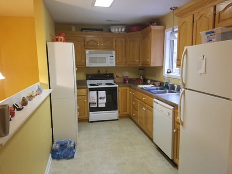Kitchen stocked with pots, pans, utensils, coffee maker, toaster, plates, bowls, etc.