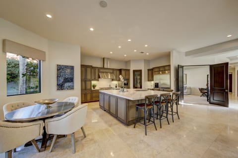 Large chefs kitchen with oversized island, bar seating and casual kitchen dining.
