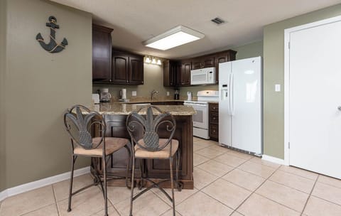 Gather around the stylish breakfast bar, perfect for enjoying meals or morning coffee in this inviting kitchen space