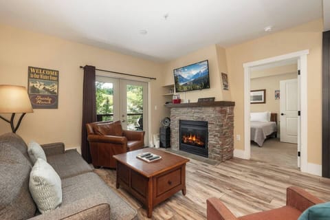 Open concept kitchen, dining and living area with gas fireplace, flat screen TV, pull-out sofa and views of the slope