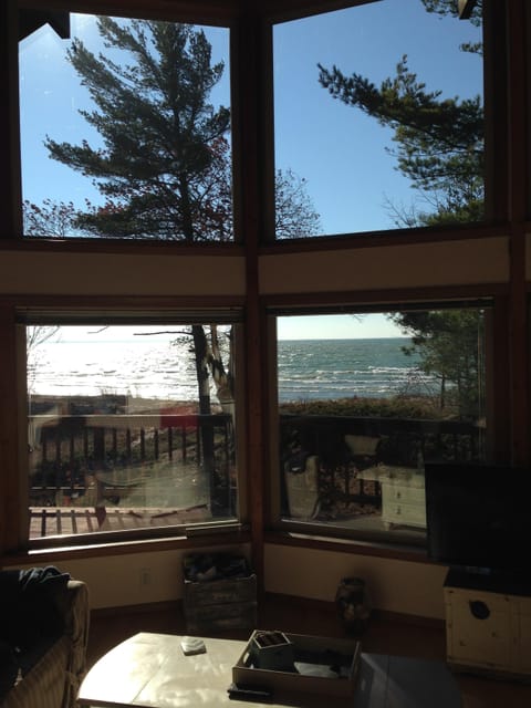 Large lakefront windows provide a stunning view of the lake in a natural setting