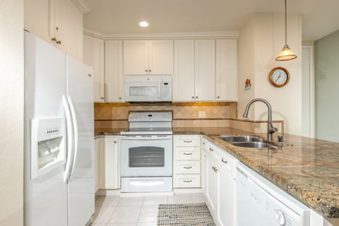 The kitchen features granite counters and stone backsplash.