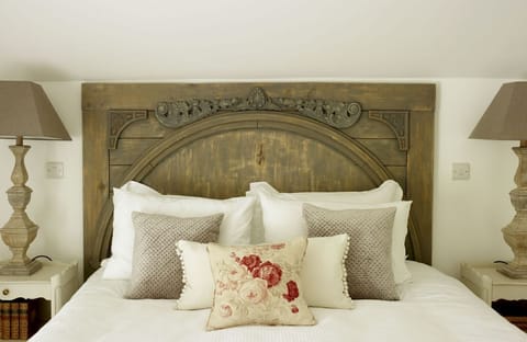 Rectory Cottage, Stamford, Cambridgeshire: The hand-carved oak headboard completes this romantic space