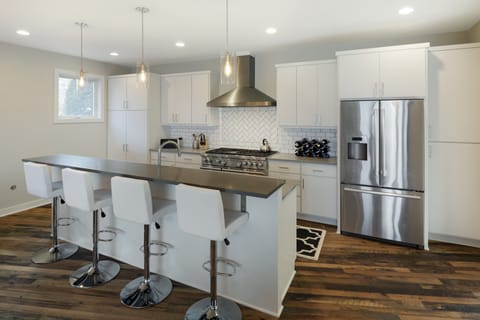 Your sleek modern kitchen awaits with gleaming stainless steel appliances, spacious island seating for four, and everything you need to create memorable meals.