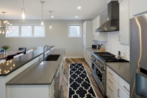 Cook memorable meals in your sleek modern kitchen with granite countertops, stainless appliances, and stylish pendant lighting creating the perfect culinary space.