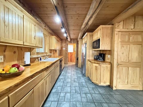 Large kitchen equipped with appliances, pots and pans, dishes, silverware, and basic cooking essentials.