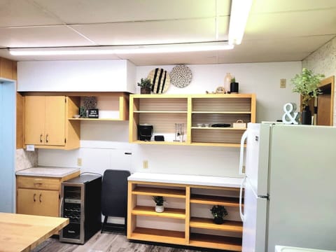 This is the west wall in the kitchen. This is located in the basement of Staycation. There is a door to the back where you can access grills, parking lot and garbage dumpster.  There is a full kitchen, stove, microwave, both types of coffee pots, dis