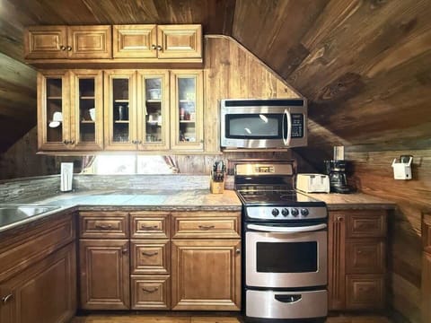 Upstairs is the kitchen with a stove, oven, microwave, fridge. and sink.