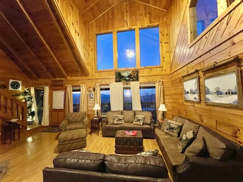 Living room with 2 couches, 1 loveseat and a accent chair with ottoman.