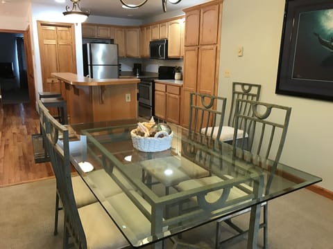 Beautiful glass top dining table seats 6 with additional seating at the island.
