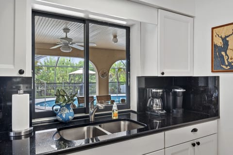 View from kitchen to lanai, pool, canal as well as 3 dining spots & family room.