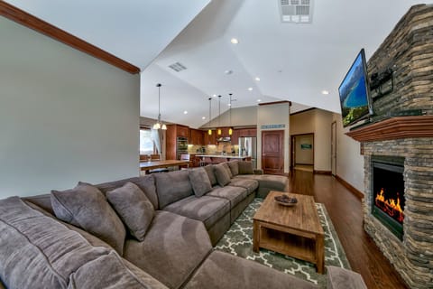 Sink into plush sectional seating by your crackling stone fireplace, while the open kitchen invites culinary adventures in this elegant retreat.