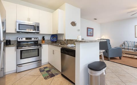 This kitchen features sleek stainless appliances, granite countertops, and a view of the living area perfect for relaxation