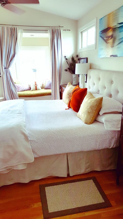 View of window seat looking out onto rustic patio + large Shumard Red Oak tree. 