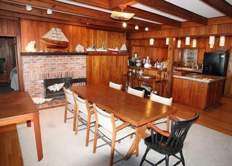 Rustic dining area with a large table and adjacent bar, perfect for family gatherings.