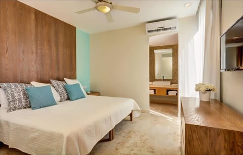 Master bedroom with king size bed, TV, and attached bathroom