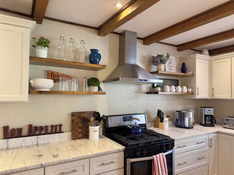A fully stocked cook's kitchen with two types of coffee makers, espresso machine