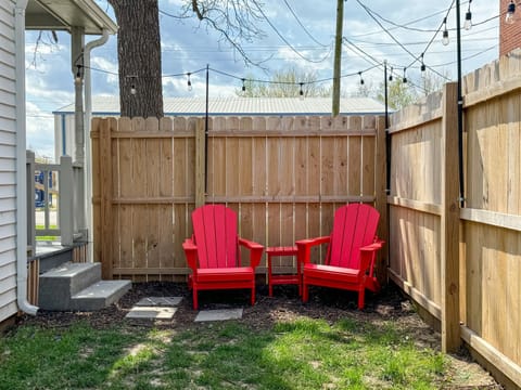 Fenced side yard with seating and twinkle lights