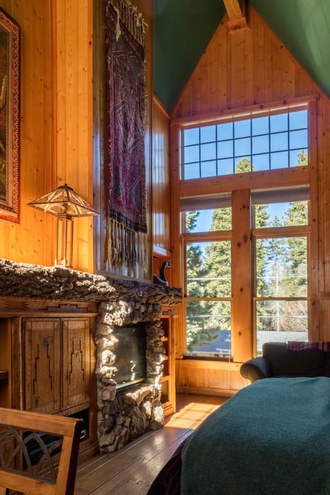 Dramatic yet restful, the bedroom sleeps two people while the hearth flickers