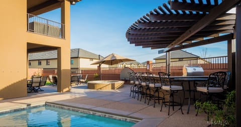 Pool, fire pit and outdoor kitchen with BBQ, bar and pergola