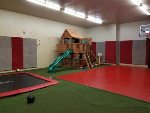 Playroom, with basketball, buried trampoline, putting green, and playhouse
