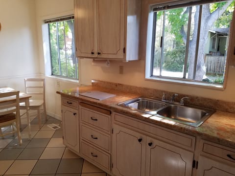 Ample counter space for food prep. Dishes, cutlery, and glassware to serve four.