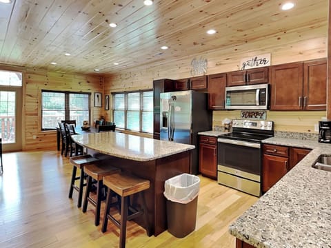 Fully Equipped Kitchen with Stainless Steel Appliances and Breakfast Bar Seating for Four
