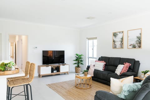 nviting living: Cozy sofa, modern TV—perfect for relaxation and entertainment. 