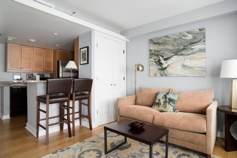 cozy living room with barstools, coffee table, and second television