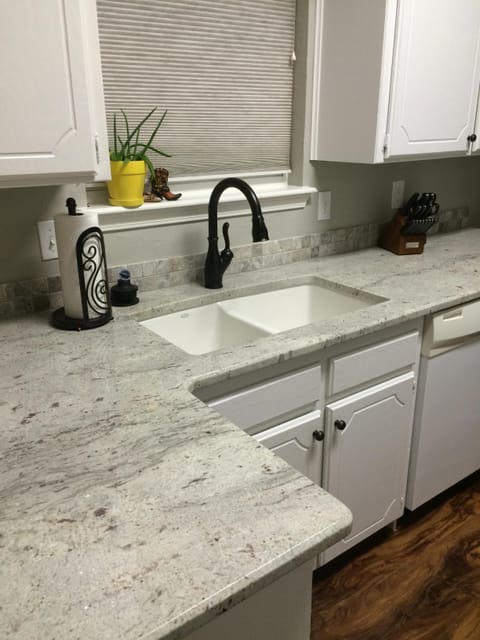 Granite countertops glisten in the sunny dine-in kitchen.