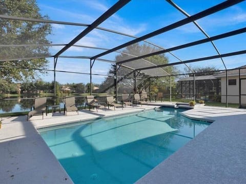Pristine swimming pool, perfect for relaxing under the screened enclosure and enjoying sunny days.