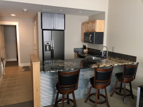 View of kitchen and bar from living room