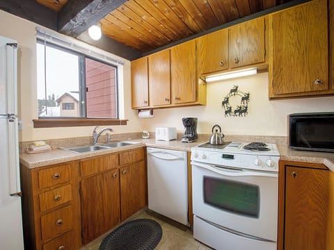 Your fully equipped kitchen awaits with warm wood cabinets, granite counters, and everything needed to create memorable meals during your stay.