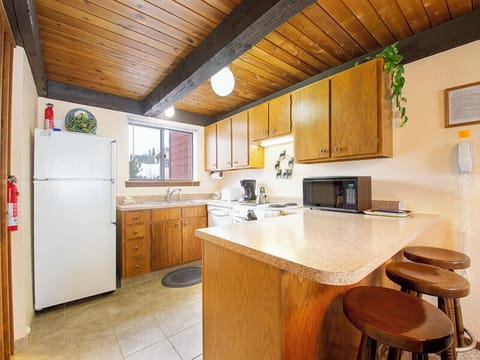 Your fully equipped kitchen welcomes you with warm wood cabinets, modern appliances, and breakfast bar seating for casual meals or morning coffee.