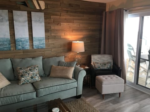 Living room with sofa bed and plenty of comfortable seating & wall of glass door