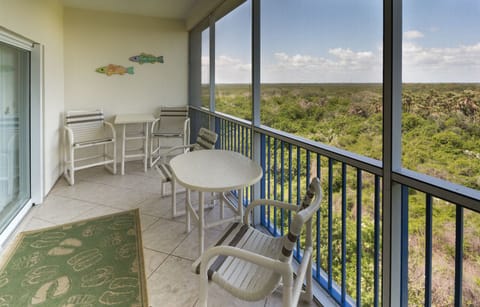 Screened in patio off of living room with table that sits 2