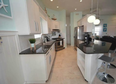 Modern coastal kitchen with granite counters and stainless-steel appliances