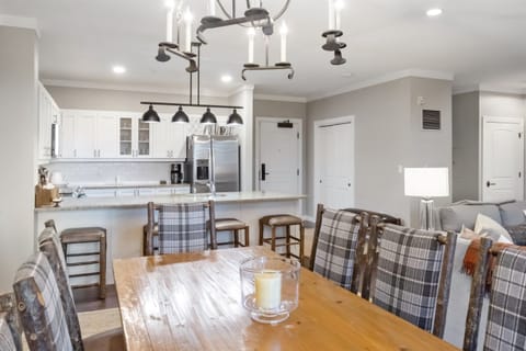- Open dining area with rustic wood table and plaid chairs   - Overlooks modern kitchen with stainless steel appliances   - Perfect for family dinners after mountain adventures