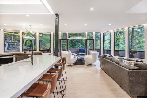 Natural light floods the kitchen and living room, boasting incredible forest views.