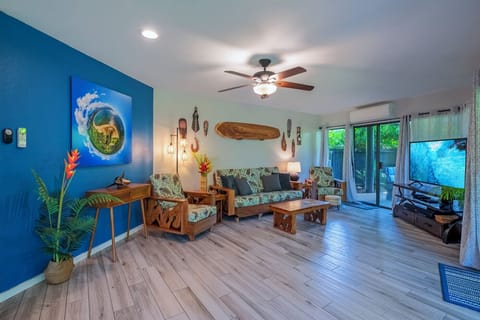 Mauna Kai 5A living room - Mauna Kai 5A has a beautifully updated interior, with real wood floors and locally sourced artwork throughout the unit!