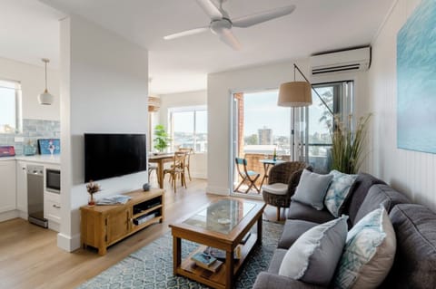 Living area with 50inch Smart TV , comfortable furnishings and a beachside feel