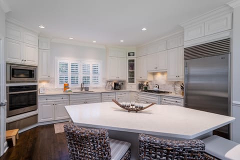 Beautiful upscale kitchen with custom cabinets, quartz counter tops and an island with additional seating.