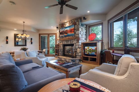Sink into plush seating by your stone fireplace, where warm wood tones and mountain views create the perfect retreat.