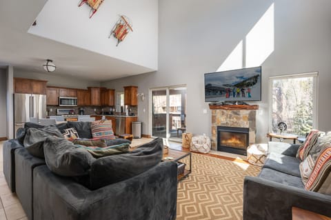 Open main level with living room, kitchen, dining area, and deck access