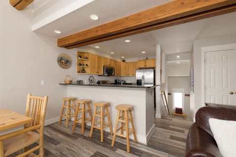 Kitchen counter with 4 stools, open to living room, dining.