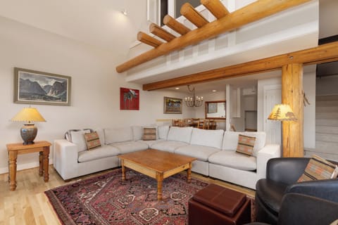 Living room with vaulted ceiling, hardwood floors, open to dining/views