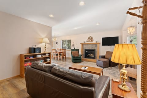Living room with windows, sofa, armchair, and recliner.