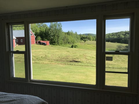 Summer view of the property's barns and meadows from the master bedroom