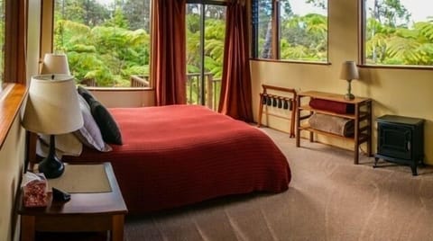 Spacious bedroom with several large picture windows and comfortable queen bed.